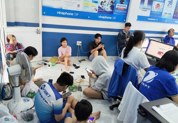 Người dân sạc pin tại điểm hỗ trợ di động Điểm hỗ trợ người dân sạc pin điện thoại trong vùng lũ